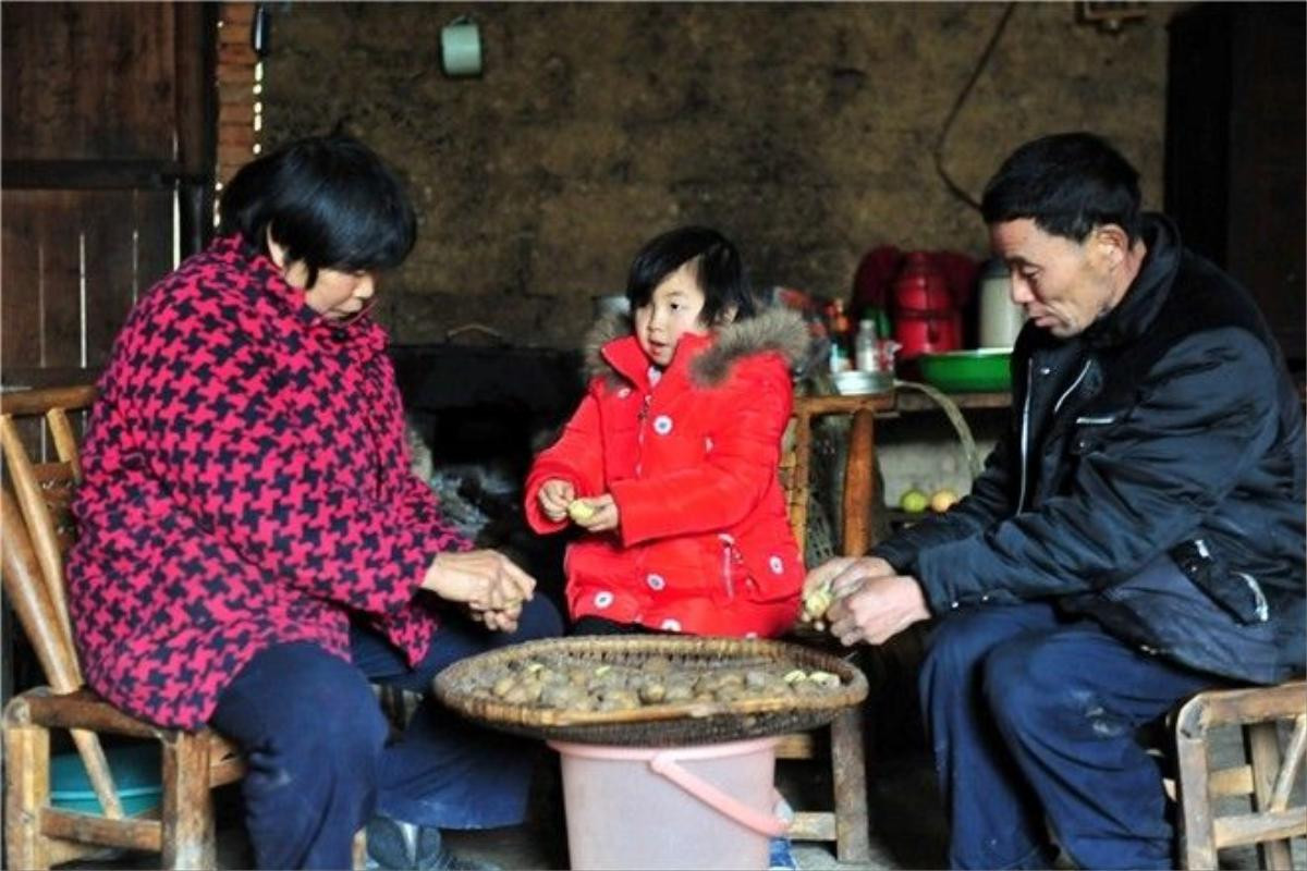 Yi Miaomiao helps her grandparents to peel potatoes, on Feb 23. In July last year, her father died in a car accident, and because of that, her mother left the family and never came back